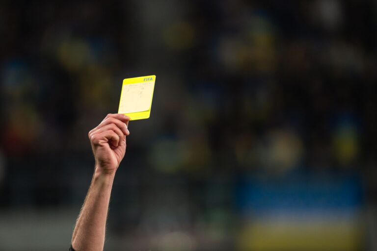 A referee shows a yellow card in the Premier League