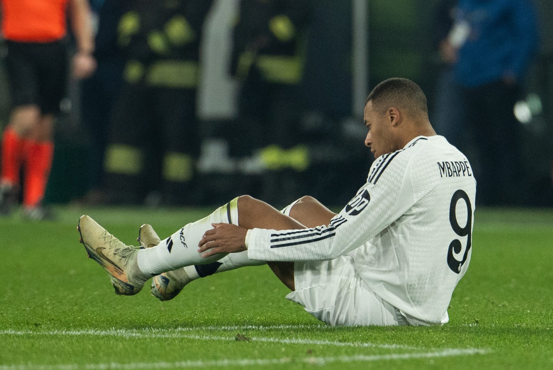 Real Madrid forward Kylian Mbappe lays on the floor injured